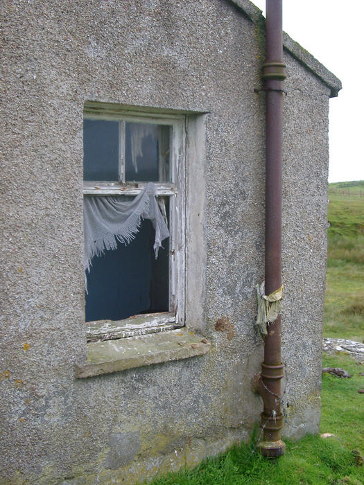 a abandoned croft building with broken windows in the outer bebrides, scotland