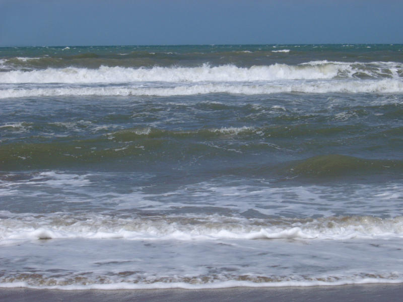 waves breaking under a stormy looking sky