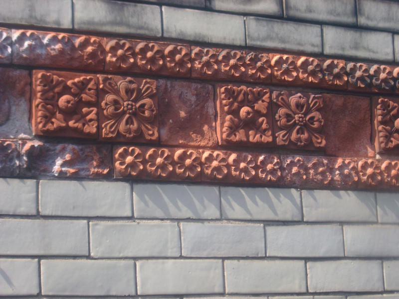 a brick wall with decorative floral motif pattern bricks