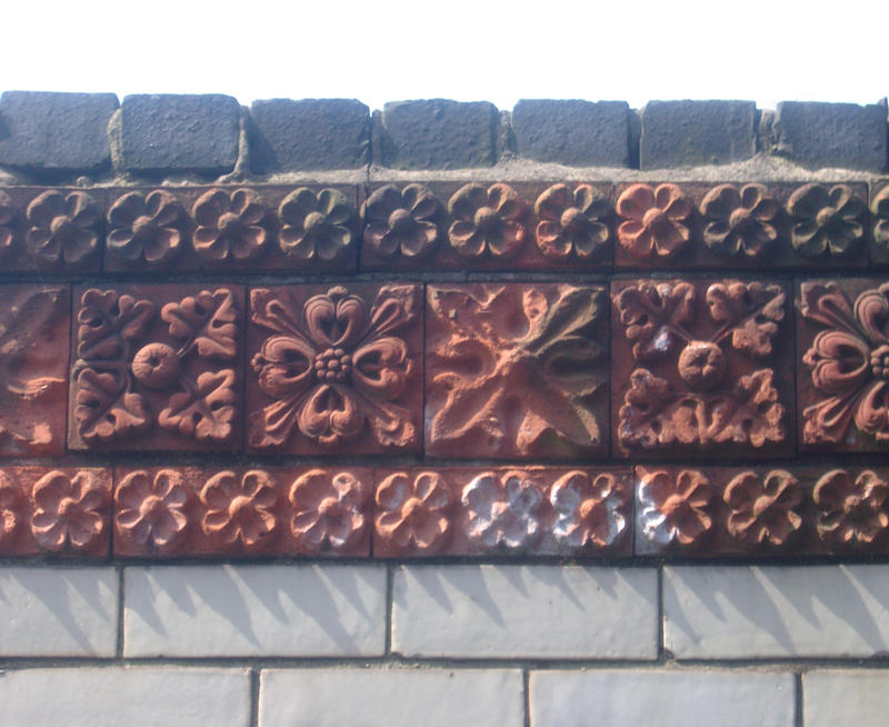 a brick wall with decorative floral motif pattern bricks