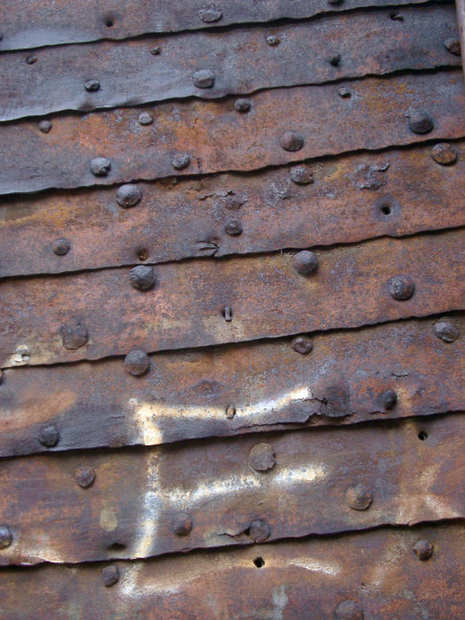 grunge background of rusted metal sheets and old rivets