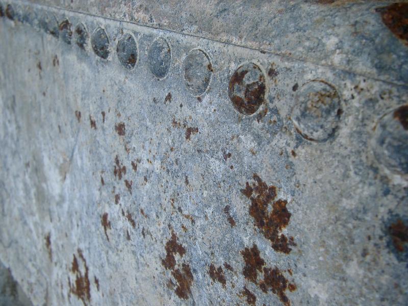 rivents and rust forming on an old metal water tank