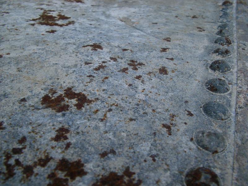 rivents and rust forming on an old metal water tank