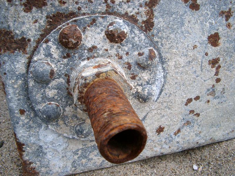details of a rusty old water tank and connecting pipe
