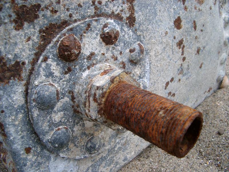 details of a rusty old water tank and connecting pipe