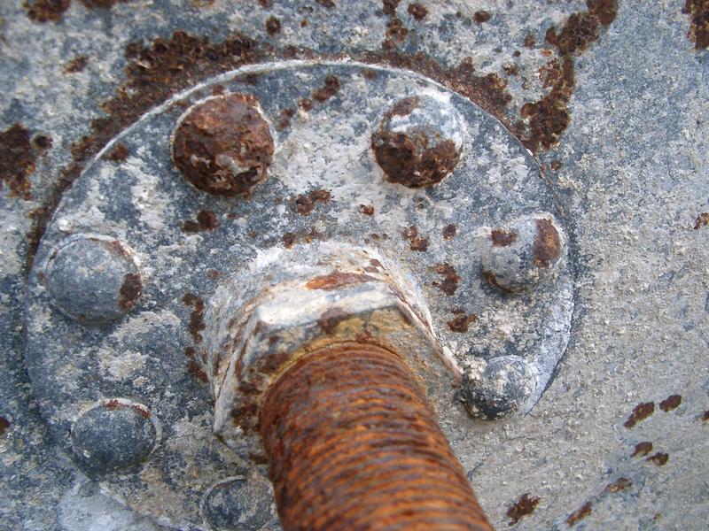 details of a rusty old water tank and connecting pipe