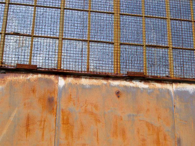 an old factory unit with rursting metal grill and windows