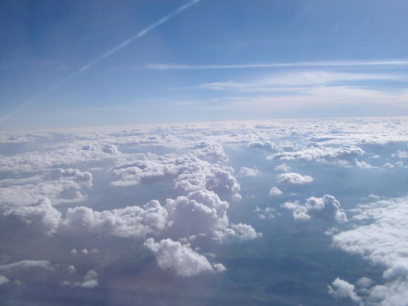 clouds and sky with a vapour trail from a passing jet aircraft