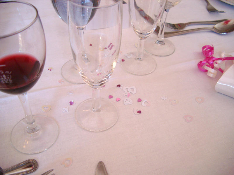 a wedding table, glass of wine and empty glasses