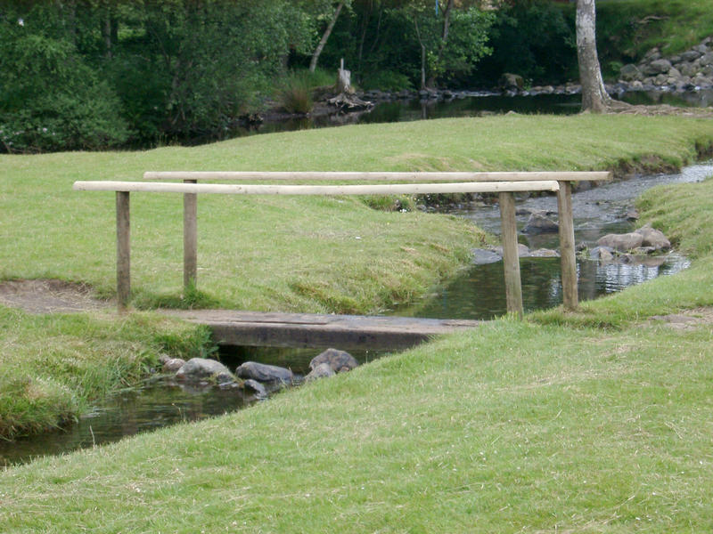 a small wooden bridge crossing a steam in the north wales hills