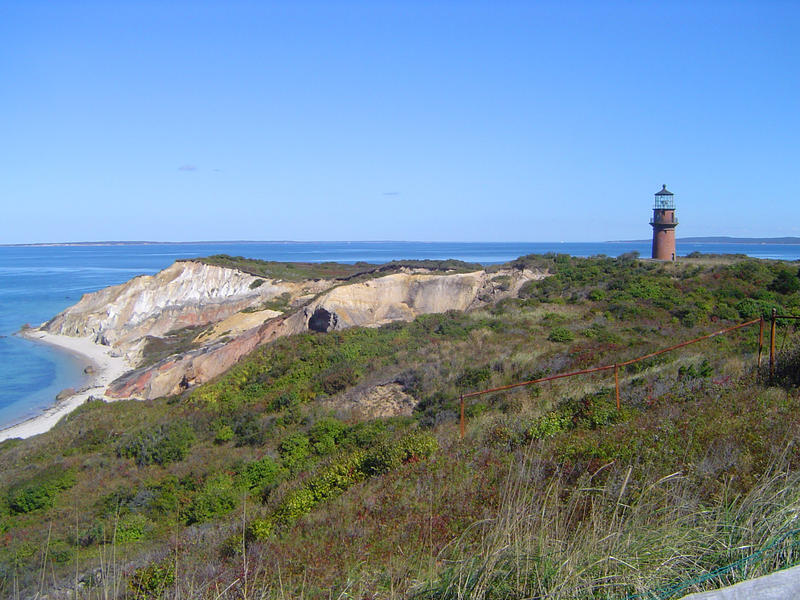 a small lighthouse atop of colored chalk cliffs