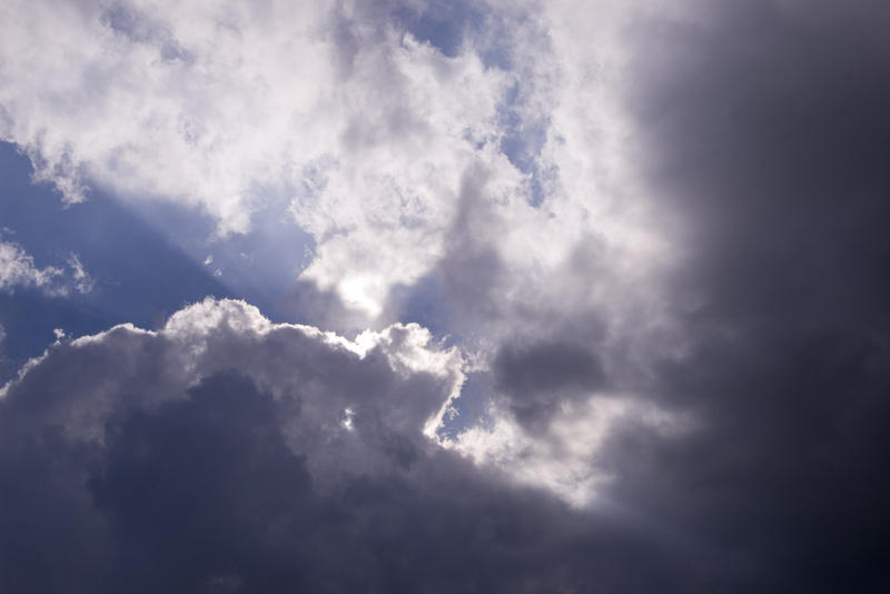 stormy looking clouds and beam sunlight with blue sky