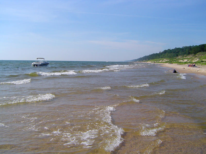 a coastal scene, sandy beach and a motor boat