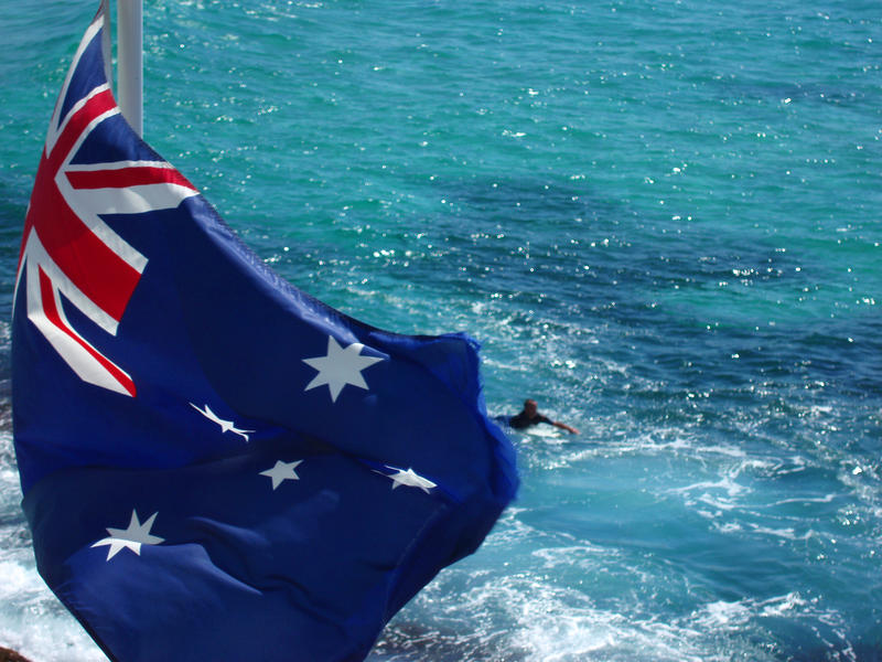 An australian flag flying in the breeze at bondi beach