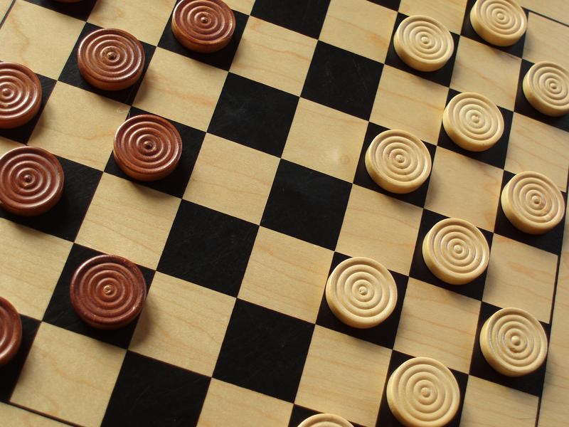 a wooden draughts or checkers with wooden counters