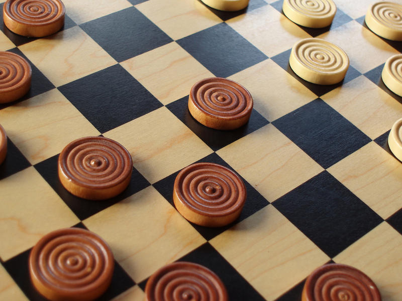 a wooden draughts or checkers with wooden counters