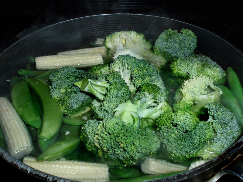 a boiling pan with fresh broccoli florets and parsnips