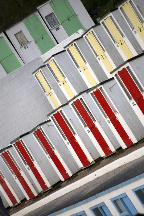 lines of colourful beach huts on Tolcarne Beach, Newquay, Cornwall