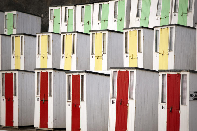 terraces of colourful beach huts on Tolcarne Beach, Newquay, Cornwall