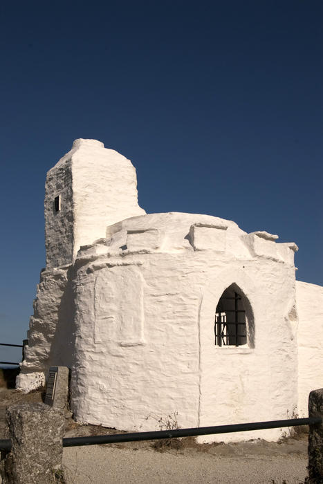 a white folly building on a headland on the cornish coast