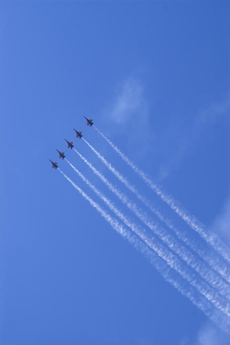 5 blue angels flying high in the sky with smoke trails