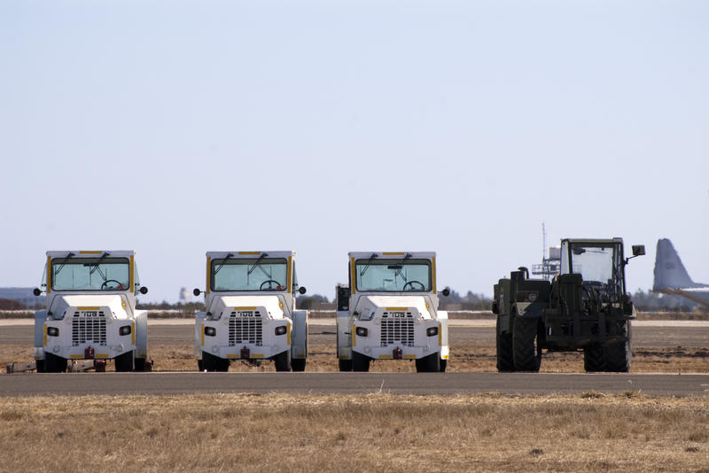a row of airfield tow trucks or tractors