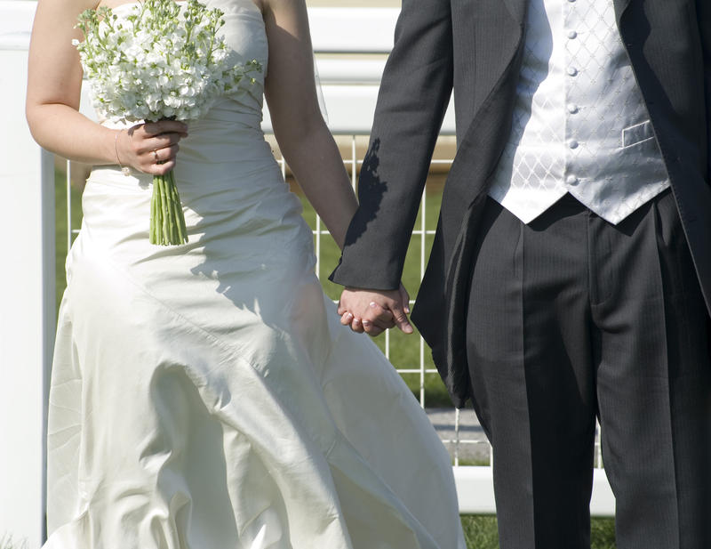 a bride and groom holding hands after being married