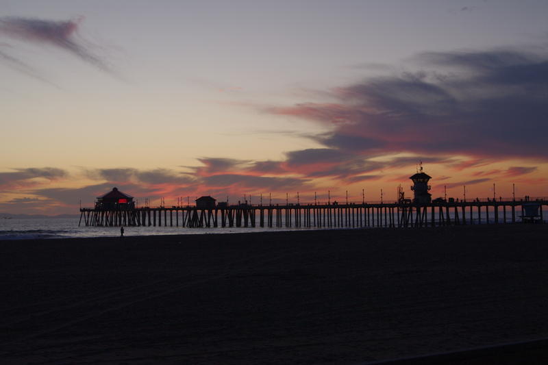 sunset through the pier at huntington beach