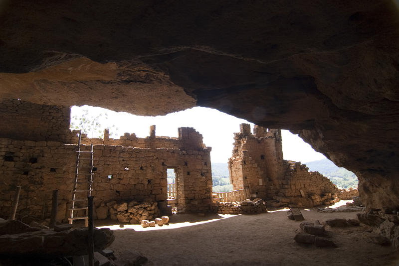 remains of cave dwellings carved into a cliff, fance