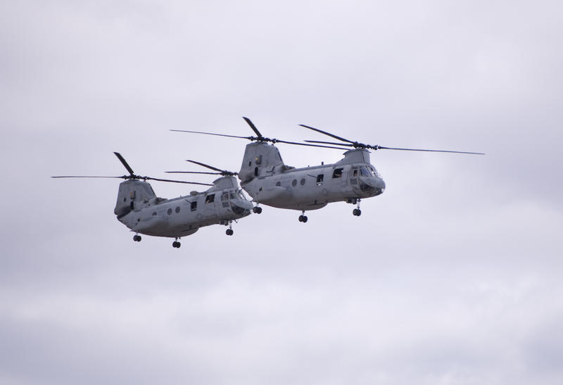 a pair of chinook helicopters in flight