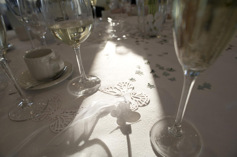 a dining table set up for a celebration meal with wine glasses and decorative confetti