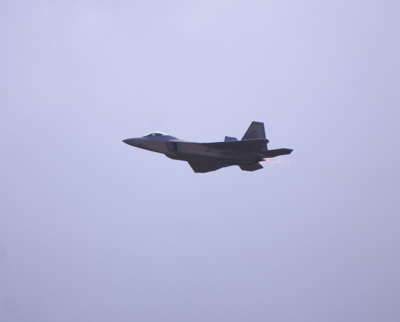 Glowing hot gas as a Lockheed Martin F-22 Raptor flys at an airshow