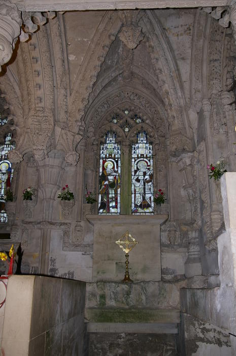 a gold cross and ornate carved church stonework