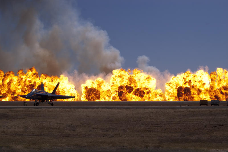 fire balls at an airshow with an FA18 in the foreground
