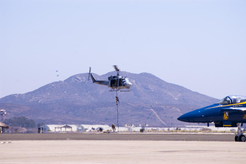 marines abseiling from a helicopter to the ground