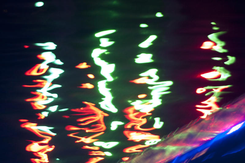 reflections of colourful lights on water at night