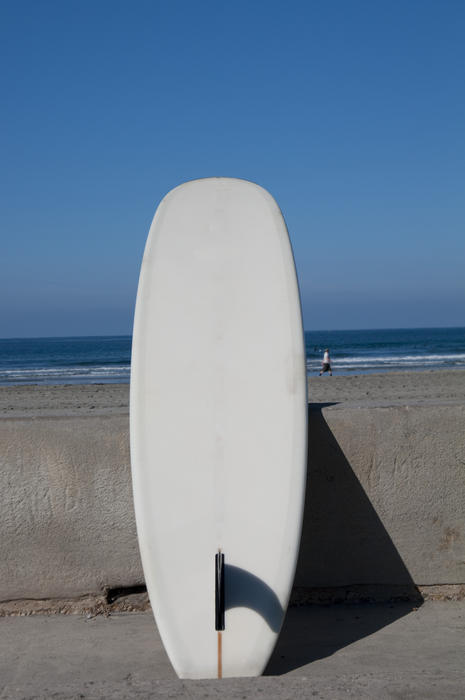 a long surf board at the beach with space for text