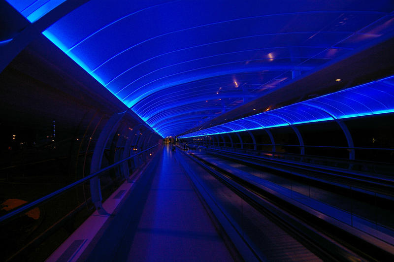 blue neon lit walkway at manchester airport