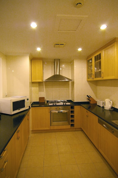 a modern kitchen interior with stainless steel cooker and marbled work surfaces