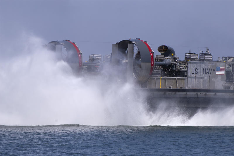 water kicked up from the fans at the back of a navy hovercraft