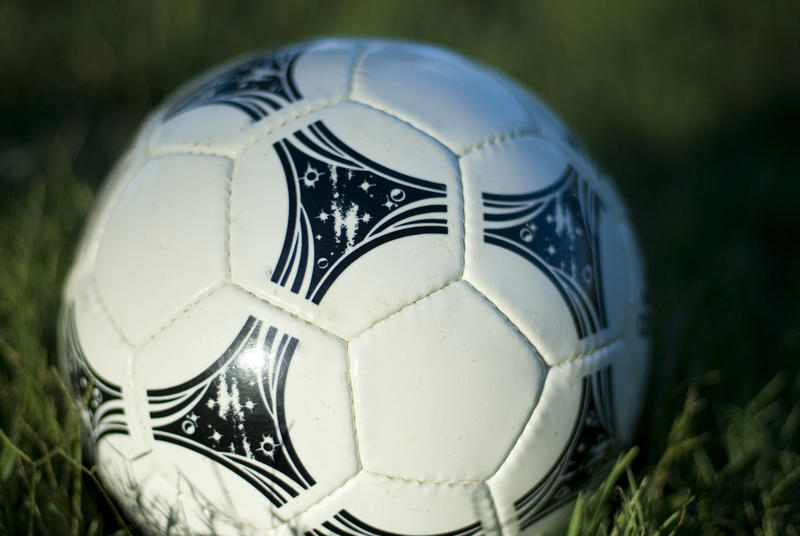 a soccer ball placed on a grassy soccer pitch