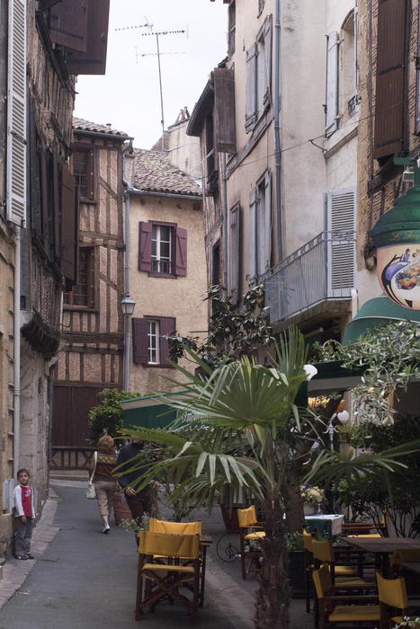 a narrow french street and pavement cafe