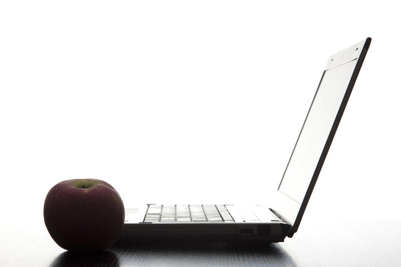 stock image concept, online and electronic education, an apple and a laptop in silhouette