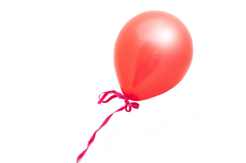 a red balloon tied with a pink ribbon cut out on white