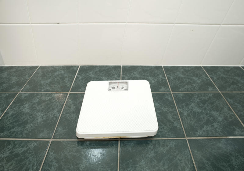 wide angle image of bathroom scales on a tiled floor