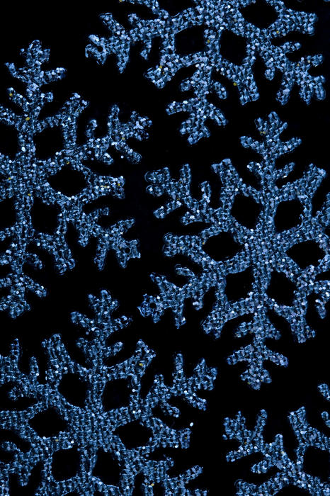a background image of blue coloured sparkling snowflake shaped christmas decorations