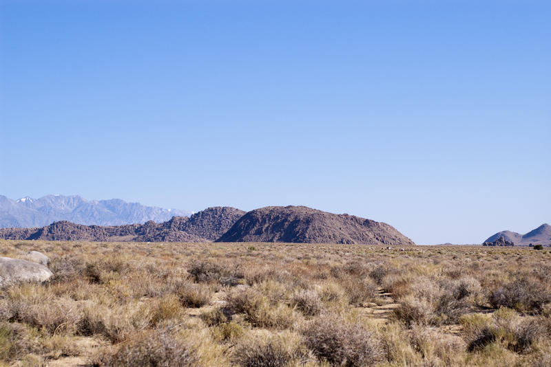 a flat desert landscape with distant hills and mountain ranges