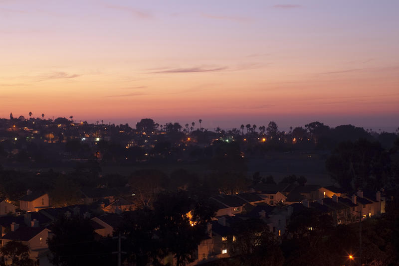 golden orange light of sunset illiminates beach side suburbs