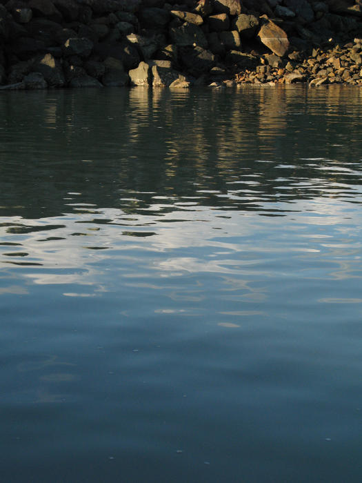 flat water sheltered from the ocean behind a marina rock wall