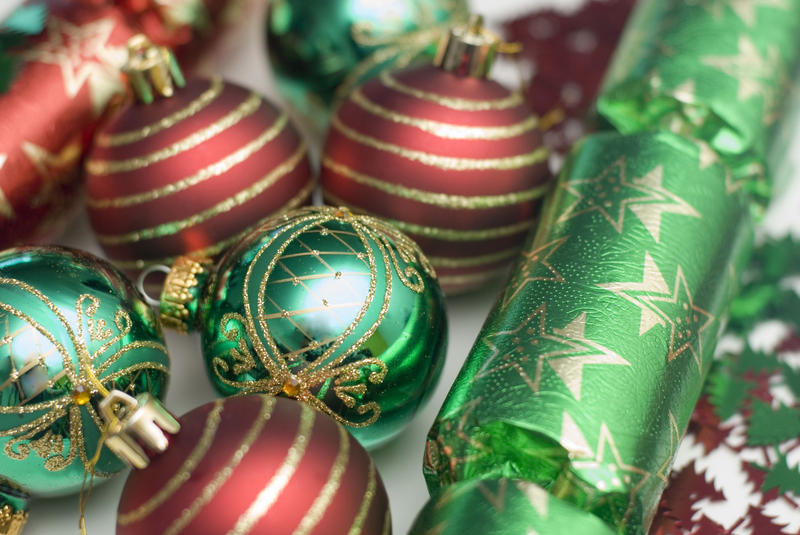an arrangement of red and green christmas baubles and crackers